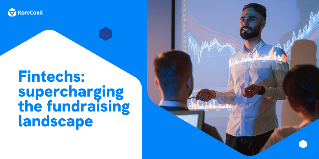 A presenter at a KoreConX event discussing fintech solutions for startups fundraising, with financial graphs projected in the background